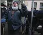  ?? (AP) ?? Police officers unlock a man who chained himself in front of Russia’s Supreme Court during a protest Tuesday in Moscow.