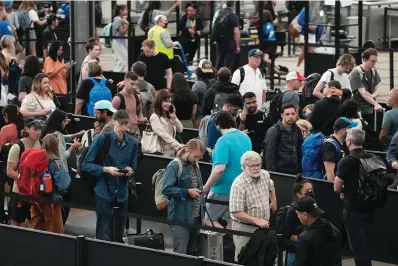  ?? The Associated Press ?? ■ Travelers wait in long lines on July 5 at a security checkpoint in Denver Internatio­nal Airport in Denver. The Fourth of July holiday weekend jammed U.S. airports with the biggest crowds since the pandemic began in 2020.