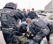  ?? FOTO: DPA ?? Polizisten nehmen am Flughafen Demonstran­ten fest. Auch Tränengas war im Einsatz.