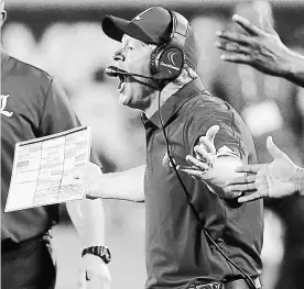  ?? STEPHEN M. DOWELL TNS ?? Louisville head coach Bobby Petrino yells to his players in a game against Alabama during the Camping World Kickoff in Orlando, Fla., in September. Louisville has fired Petrino.