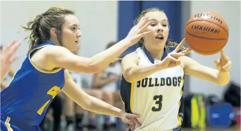  ?? JULIE JOCSAK/STANDARD STAFF ?? Lauren Vanecko of the Sir Winston Churchill Bulldogs shoots the ball away from Tess Puchalski of the E.L. Crossley Cyclone at E.L. Crossley during the 14th Tribune Girls Basketball Tournament on Wednesday.