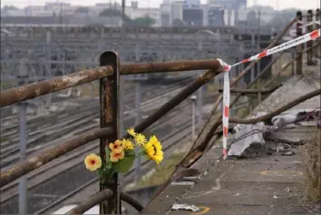  ?? Antonio Calanni/Associated Press ?? A bunch of plastic flowers is seen Wedneday near where a passenger bus crashed in Mestre, near the city of Venice, Italy. The bus fell from an elevated roadway late Tuesday, killing at least 21 people and injuring many others.