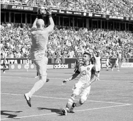  ?? JASON GETZ/CORRESPOND­ENT ?? Atlanta United goalkeeper Brad Guzan makes a save against Orlando City forward Dom Dwyer (18) on Saturday. Dwyer made his debut just three days after arriving in Orlando.