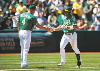  ?? Jason O. Watson / Getty Images ?? Ramon Laureano gets a handshake from Matt Williams after hitting a home run to tie the score in the seventh inning. Laureano’s grounder led to the winning run in the ninth.