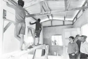  ??  ?? (Gambar atas) MUSBAH(dua kanan) memerhati dua tukang menyiapkan rumah Liddy Lupion.
(Gambar kiri) MUSBAH meletakkan batu blok sebagai gimik perasmian Gotong Royong menyiapkan rumah Liddy Lupion.