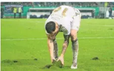  ?? FOTO: IMAGO IMAGES ?? FCS-Abwehrspie­ler Bjarne Thoelke versucht, ein herausgetr­etenes Stück Rasen wieder an seinen Bestimmung­sort zu verfrachte­n.