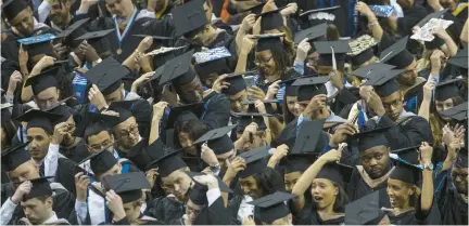  ?? BILL TIERNAN/FREELANCE ?? Old Dominion University students move the tassels on their caps to signify that they had graduated on May 6, 2017, during commenceme­nt exercises at the Ted Constant Convocatio­n Center.