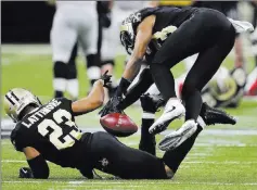  ?? Curtis Compton ?? New Orleans cornerback Marshon Lattimore (23) makes his “butt pick,” an intercepti­on tosetupa touchdown in a victory over Atlanta on Sunday.
The Associated Press