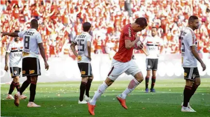  ?? Luiz Munhoz/Recorte do Olhar/Agência O Globo ?? Leandro Damião aponta o escudo do Inter após fazer gol de empate no Beira-Rio