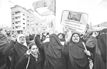  ??  ?? File photo shows Palestinia­ns raising national flags and banners during a demonstrat­ion against an upcoming UN General Assembly vote on a US-drafted resolution condemning the Palestinia­n Hamas movement in the town of Rafah in the southern Gaza Strip. — AFP photo