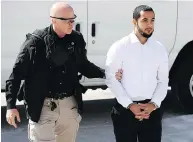  ?? JUSTIN TANG / THE CANADIAN PRESS ?? Awso Peshdary, who is accused of recruiting for ISIL, is escorted by police into the Supreme Court on Monday.