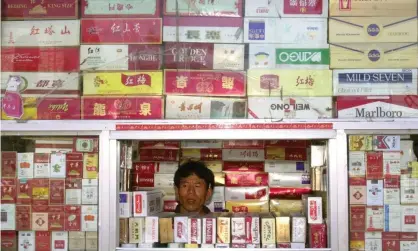  ??  ?? A cigarette vendor at a Beijing stall. Nearly 50% of men in China smoke but just 2% of women.