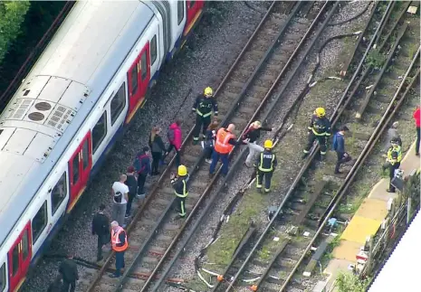  ??  ?? Rescatista­s ayudan a pasajeros a salir del tren de la estación Parsons, en Londres, tras la explosión registrada ayer por la mañana. La primera ministra denunció lo que llamó un “cobarde ataque terrorista” que pretendía causar un “daño importante”.