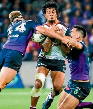  ?? BRENDON RATNAYAKE/PHOTOSPORT ?? Warriors’ James Gavet tries to break through two tacklers during Tuesday night’s NRL match against the Melbourne Storm at AAMI Park.