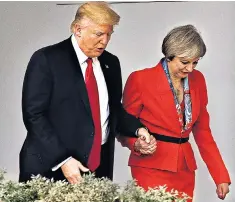 ??  ?? Donald Trump takes Theresa May’s hand as they walk along the White House colonnade