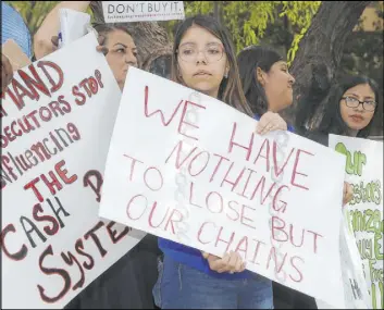  ?? Ross D. Franklin The Associated Press ?? Annette Alvarez, middle, joins other protesters against high bail Thursday in front of Maricopa County Attorney Bill Montgomery’s office in Phoenix.