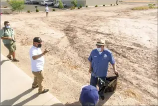  ?? PHOTO VINCENT OSUNA ?? Aurora High School Principal John Moreno (right) uses a grabber tool to pick up litter during the Calexico Earth and Arbor Day community clean up event on Saturday in Calexico.