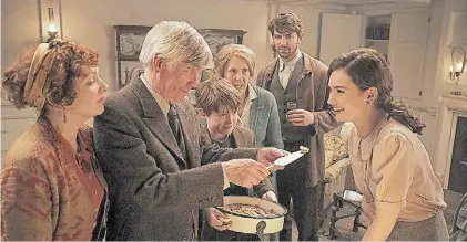  ??  ?? A probar. La escritora (Lily James) acepta una porción del pastel de papa que le da Tom Courtenay.