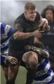  ?? CLINT HUGHES/THE ASSOCIATED PRESS ?? Toronto Wolfpack’s Jack Bussey churns through the mud and Siddal’s Joe Martin on Saturday.