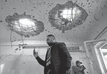  ?? MUHAMMAD ISMAIL / REUTERS ?? Journalist­s film inside a classroom on Tuesday after a terror attack at Kabul University in the Afghan capital.