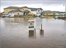  ?? Gina Ferazzi Los Angeles Times ?? A NEIGHBORHO­OD is f looded Wednesday in the Tulare County town of Woodlake. Recent heavy rain has upended thousands of lives in the Central Valley.