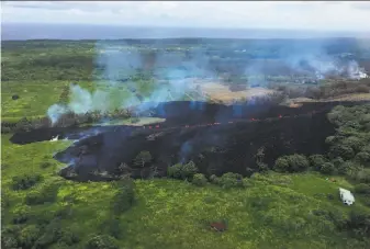  ?? U.S. Geological Survey ?? Gases rise Sunday from a fissure that opened near the town of Pahoa. Nearly 2,000 people have been told to evacuate since May 3, and lava has destroyed more than two dozen homes.