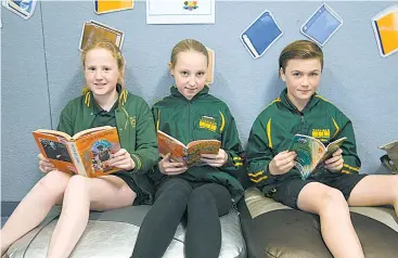  ??  ?? Garfield Primary School students Sarah Martin, Erika Sartori and Kade Nibbs settle down with a book.