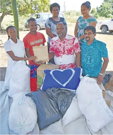  ?? Photo: Shratika Naidu ?? Unaisi Dimaimuri (left), with her brother Sarusi Drauna receiving the donation collected by Labasa Muslim College teachers and students.