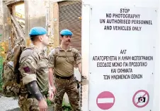  ?? ?? Members of the United Nations Peacekeepi­ng Force in Cyprus close a door while patrolling along the buffer zone.
