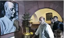  ?? Prakash Singh/Getty Images ?? India’s Home Minister, Rajnath Singh walks past a photograph of Sardar Vallabhbha­i Patel. A planned $33 million statue of the independen­ce leader has caused an outcry in the South Asian country.