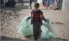  ?? ?? A boy with plastic sheets to use for his family’s shelter in Rafah. Palestinia­ns’ makeshift tents give little protection in the winter, when temperatur­es can drop below 10C. Photograph: Getty