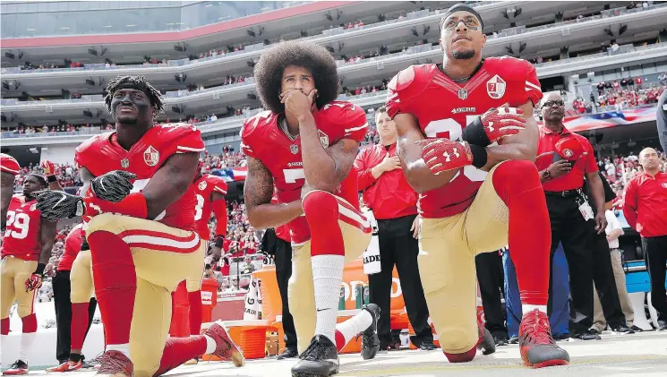  ?? MARCIO JOSE SANCHEZ/AP ?? Quarterbac­k Colin Kaepernick, centre, sparked criticism last year when he knelt during pre-game renditions of the U.S. national anthem. Now he’s struggling to find work.