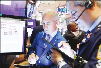  ??  ?? Trader Timothy Nick (left), works on the floor of the New York Stock Exchange. (AP)