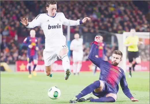  ??  ?? Real’s Mesut Ozil from Germany, left, and Barcelona’s Gerard Pique vie for the ball during a Copa del Rey soccer match between FC Barcelona and Real Madrid at the Camp
Nou stadium in Barcelona, Spain, Tuesday, Feb. 26. (AP)