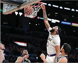  ?? ALEX GALLARDO / AP ?? Lakers forward Anthony Davis, second from right, dunks against Spurs forward Drew Eubanks, left, guard Devin Vassell, second from left, and forward Doug McDermott, right, during the first half of Sunday’s game in Los Angeles.