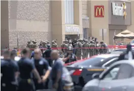  ??  ?? Law enforcemen­t personnel from several agencies respond to a mass shooting at a Walmart in El Paso on Saturday.