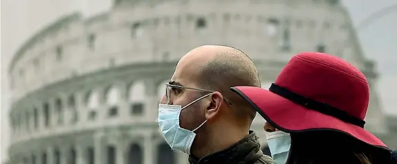  ?? (Afp/Filippo Monteforte) ?? Al Colosseo Una coppia con la mascherina passeggia in pieno centro a Roma. Ieri nel Lazio i nuovi positivi sono stati 795