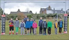  ??  ?? Coach Euan Rains joins his young players for a team photograph.