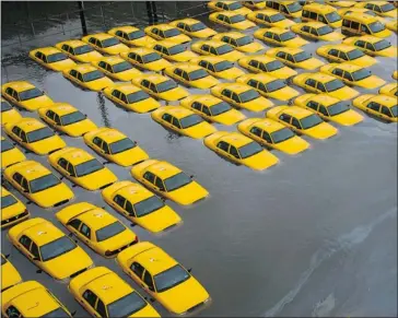  ?? Charles Sykes/the Associated Press ?? A parking lot full of yellow cabs in Hoboken, N.J. waits Tuesday for floodwater­s dumped by superstorm Sandy to ebb.