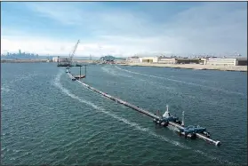  ?? AP ?? A long floating boom that will be used to corral plastic litter in the Pacific Ocean is assembled Monday in Alameda, Calif. Engineers will deploy a trash collection device to corral plastic litter floating between California and Hawaii to clean up the world’s largest garbage patch. The 2,000-foot-long floating boom was towed Saturda from San Francisco to the Great Pacific Garbage Patch, an island of trash twice the size of Texas.