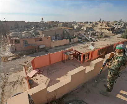  ?? AP ?? An Iraqi Christian soldier from Nineveh Plain Protection Unit stands guard on the top of the St. Addai church which was damaged by Daesh terrorists during their occupation of Keramlis village, around 29km from Mosul. —