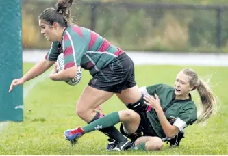  ?? CLIFFORD SKARSTEDT/EXAMINER ?? Holy Cross Hurricanes' Laura Sicker drags an Adam Scott Lions player towards the end zone for a try during junior girls rugby action on Friday at Holy Cross Secondary School field. The Hurricanes beat the Lions 40-0 for an undefeated regular season...