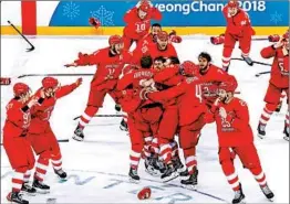  ?? HARRY HOW/GETTY ?? Russian team members fling away their gloves and sticks and join in celebratin­g their gold medal in hockey after beating Germany on Kirill Kaprizov’s goal in overtime.