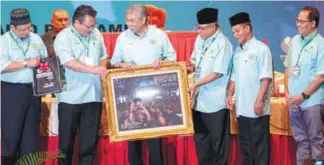 ??  ?? Ahmad Zahid receiving a souvenir from Nur Jazlan (second from left) at the launch of the 42nd Malaysian Drug Prevention Associatio­n general assembly yesterday.