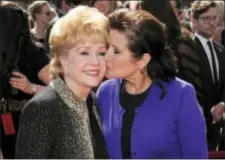  ?? CHRIS PIZZELLO — THE ASSOCIATED PRESS FILE ?? In this file photo, Carrie Fisher kisses her mother, Debbie Reynolds, as they arrive at the Primetime Creative Arts Emmy Awards in Los Angeles. The mother-daughter actresses will be honored at a public memorial on Saturday at the storied Hollywood...