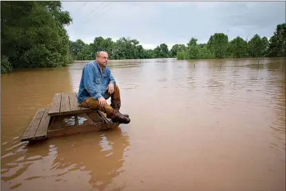  ?? Staff photo by Evan Lewis ?? Gary Rowland of Texarkana, Ark., talks with a member of the media Saturday in Garland City, Ark. Rowland and others were at the riverside home of Robert Bibby for a final get-together before rising water from the Red River takes the house.