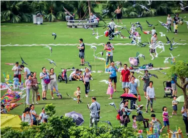  ?? ?? Locals enjoy leisure time during weekends with their families on the picturesqu­e Yundang lakeside.