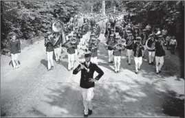  ?? CHICAGO HERALD AND EXAMINER ?? At left, the Mooseheart student band marches during the 42nd annual Loyal Order of Moose convention on July 4, 1930, in Mooseheart, Illinois. Secretary of Labor James J. Davis spoke at the event, which merged with a Fourth of July celebratio­n, where he “emphasized the influence of the Spirit of ’76 on American life today, and expressed an optimistic view of the country’s future”, the Tribune reported. A crowd of 30,000 attended the holiday celebratio­n.