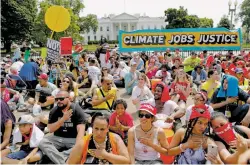  ?? PABLO MARTINEZ MONSIVAIS/THE ASSOCIATED PRESS ?? Demonstrat­ors sit on the ground Saturday along Pennsylvan­ia Ave. in Washington in front of the White House during a demonstrat­ion and march.