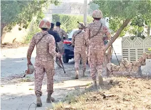  ?? — Gambar Reuters ?? POLIS dan pasukan separa tentera kelihatan sewaktu serangan ke atas konsulat China, di mana letupan dan tembakan kedengaran, di Karachi, Pakistan, semalam.